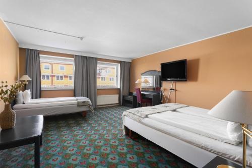 a hotel room with two beds and a flat screen tv at Best Western Hotel Bollnas in Bollnäs