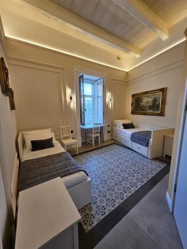 a hotel room with two beds and a table at Portus Noir Valletta in Valletta