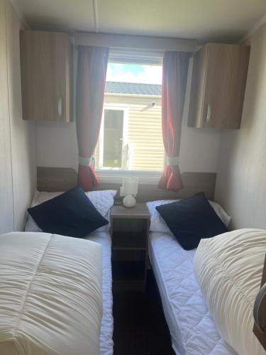 two twin beds in a room with a window at Sea Salt in Padstow
