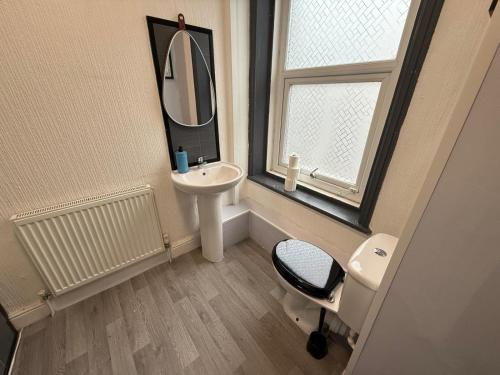 a bathroom with a sink and a mirror and a chair at ONYX Hotel Blackpool in Blackpool