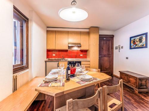 a kitchen with a wooden table with plates and wine glasses at Apartment Fondue by Interhome in Madesimo