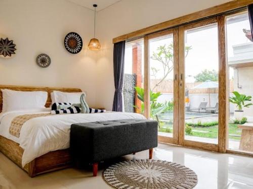 a bedroom with a bed and a large window at Ramaiin guest house in Nusa Dua