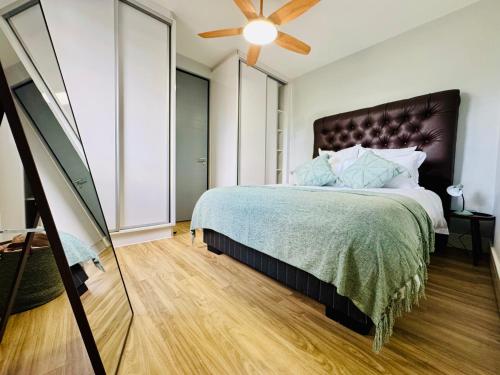 a bedroom with a large bed and a ceiling fan at Keddy J Apartments in Windhoek