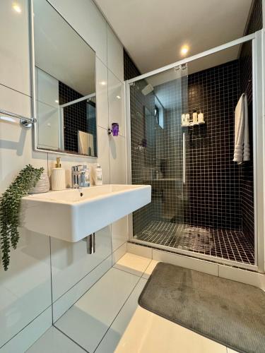 a bathroom with a sink and a glass shower at Keddy J Apartments in Windhoek