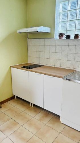 a kitchen with white cabinets and a counter top at Station Studio - Proche RER A - Wifi in Noisy-le-Grand