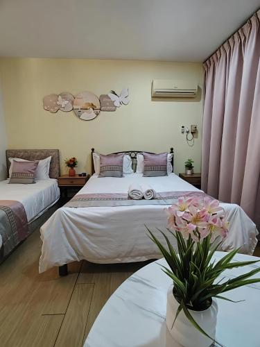 two beds in a room with pink curtains at RIVERBANK SUITE with riverfront mountain DUN view in Kuching