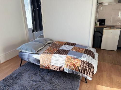 Super appartement في Malesherbes: غرفة نوم بها سرير مغطى ببطانية