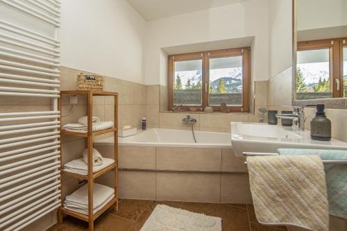 a bathroom with a tub and a sink at Ferienwohnung Bergblick in Filzmoos