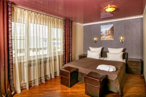 カルーガにあるYolki Apartmentsのベッドルーム1室(ベッド1台、大きな窓付)