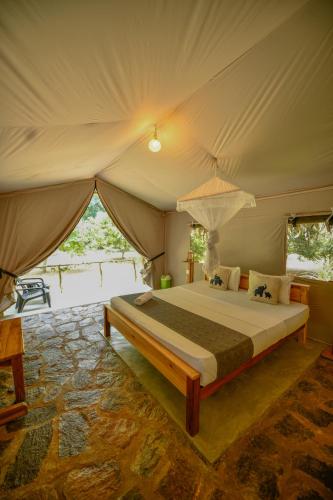 a bedroom with a bed in a tent at Jungle View River Camping in Udawalawe