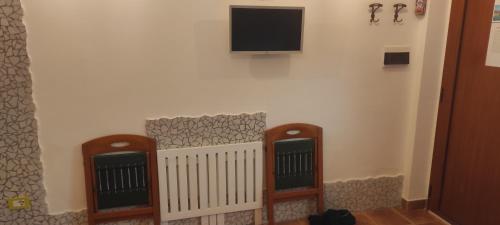 a corner of a room with a tv on a wall at Sperlonga Tiny Room in Sperlonga