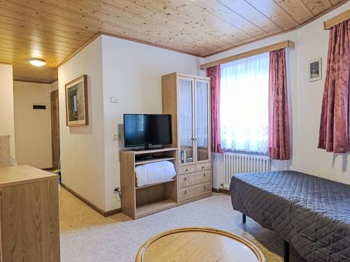 a bedroom with a bed and a flat screen tv at Apartment Cesa Cristina by Interhome in Campitello