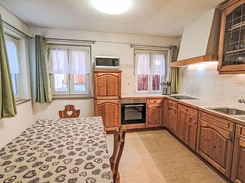 a kitchen with wooden cabinets and a table in it at Apartment Cesa Cristina by Interhome in Campitello