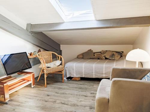 a bedroom with a bed and a tv and a couch at Apartment Barasteguia by Interhome in Ciboure