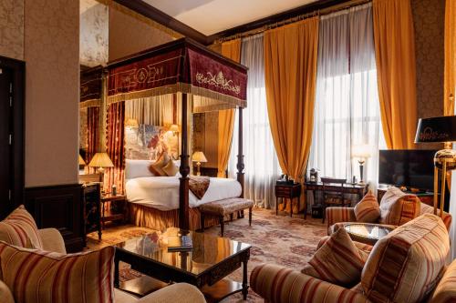 a bedroom with a canopy bed and a living room at The Merchant Hotel in Belfast