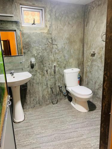 a bathroom with a toilet and a sink at Samson's Home in Hiriketiya