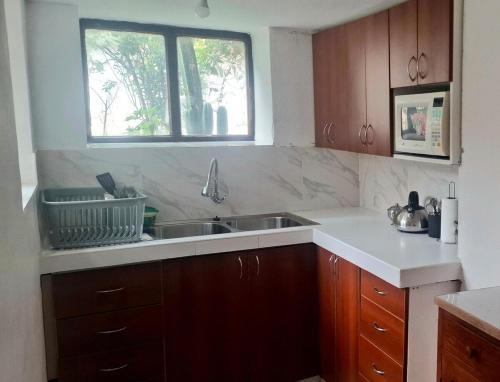 a kitchen with a sink and a window at The Green Corner Urubamba in Urubamba