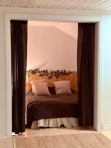 a bedroom with a large bed with black curtains at Tunnelmallinen saunallinen ullakkohuoneisto Ravintola Sampon yläkerrassa in Kuopio