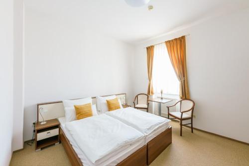 a bedroom with a bed and a desk and a window at Eagle Hotel in Šamorín
