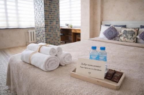 een hotelkamer met handdoeken en waterflesjes op een bed bij Квартира в тихом районе-идеально для семьи и командировки in Doesjanbe