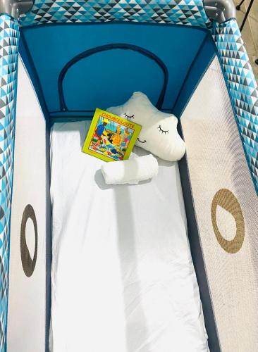 a childs bed with a stuffed animal and a book at Emeraude tropicale in Goyave