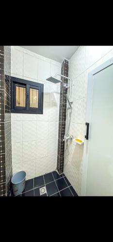 a bathroom with a shower with a black tile floor at Lita Residence in Yaoundé