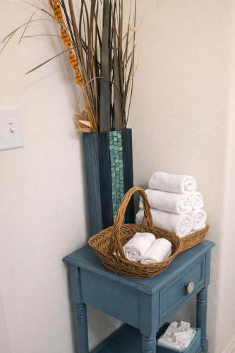 a basket of towels on a blue table with a vase at Imani in Manor