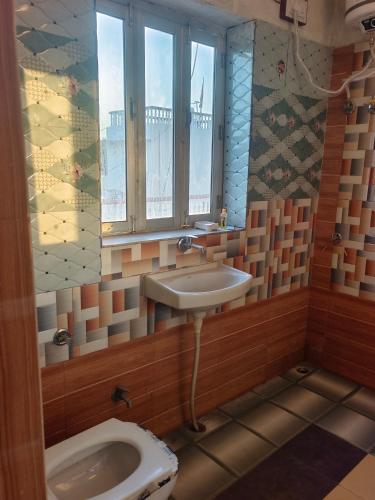 a bathroom with a sink and a toilet at Hotel Sukhdev in Nawalgarh