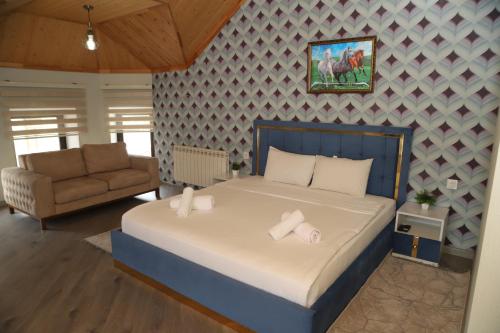 a bedroom with a large bed and a couch at Qusar Shahdag Garden Hotel in Qusar