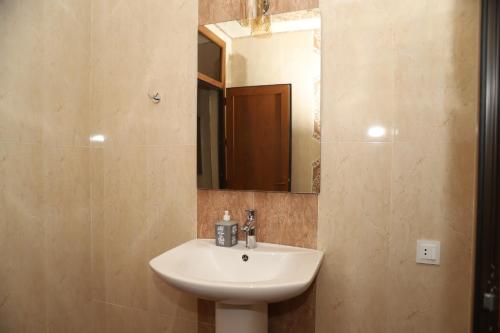 a bathroom with a sink and a mirror at Qusar Shahdag Garden Hotel in Qusar