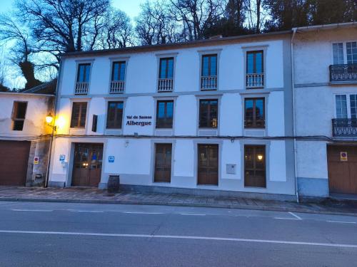 a white building on the side of a street at Albergue Val de Samos in Samos