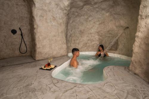 a man and a woman in a hot tub in a cave at Capetan Nikolas-boat house in Klima