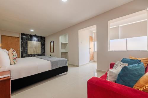 a bedroom with a bed and a red couch at Hostel Dorado Plaza Getsemaní in Cartagena de Indias