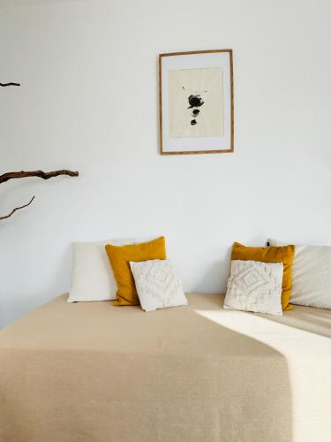 a bed in a white room with yellow pillows at M Butterfly in Alvorge