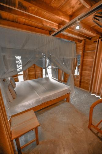 a large bed in a room with a wooden ceiling at Jungle View River Camping in Udawalawe