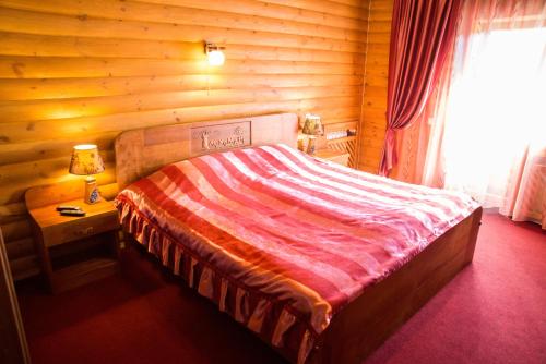 a bedroom with a bed in a log cabin at Gluhoman in Poltava