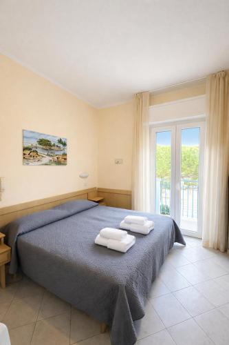 a bedroom with a bed with two towels on it at Hotel Giove dipendenza Hotel Fiamma in Cesenatico