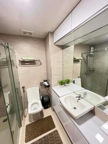 a bathroom with a toilet and a sink and a shower at Antara Residential Condominium in Talisay