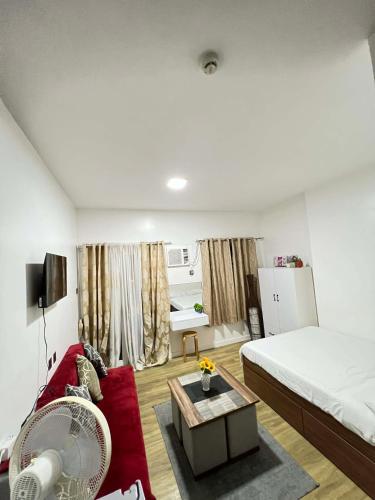 a bedroom with a bed and a red couch at Antara Residential Condominium in Talisay