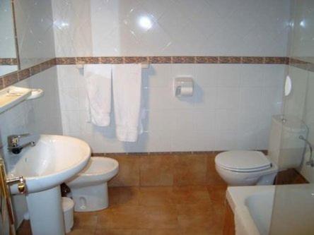 a bathroom with a white toilet and a sink at Apartamentos Picu Castiellu in La Galguera
