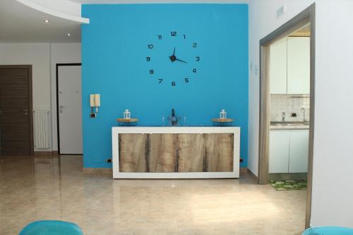 a large blue wall with a clock on it at Luca's House - Villa sul mare con piscina in Giovinazzo