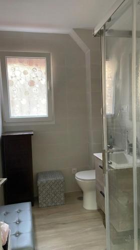 a bathroom with a toilet and a sink and a window at Casa Bueu Pontevedra in Bueu