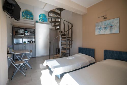 a room with a bed and a spiral staircase at Elia Luxury Apartments in Stavros