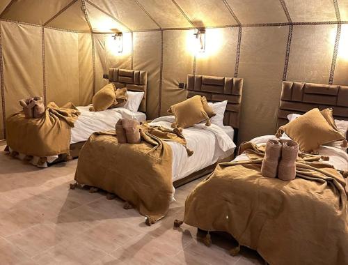 a room with two beds in a tent at Milagro Luxury Camps in Merzouga
