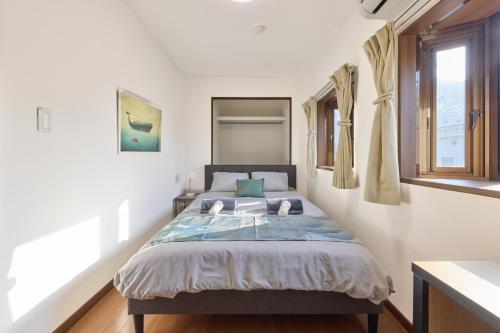 a bedroom with a bed and a window at Shinagawa Villa in Tokyo
