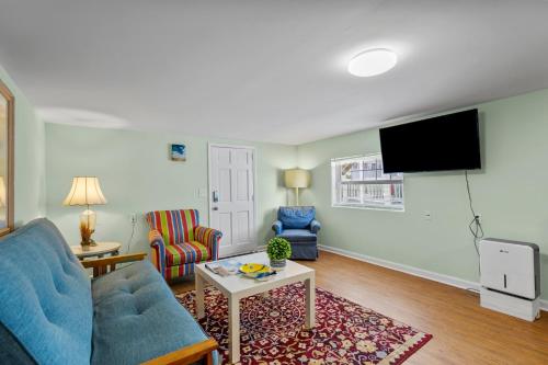 a living room with a blue couch and a tv at Sand Dollar Suites 1 in Carolina Beach