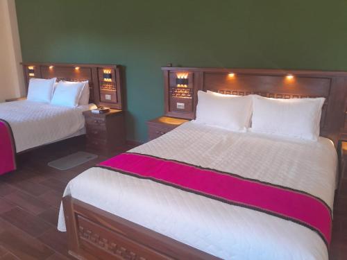 a hotel room with two beds with white and pink sheets at Hotel Norte Potosí in Torotoro