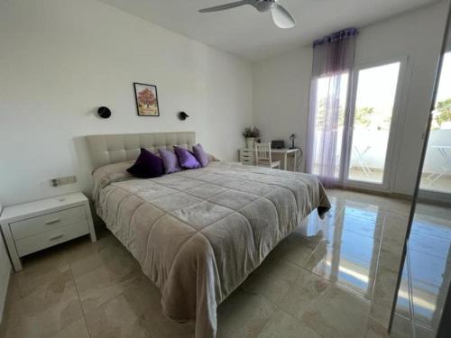 a bedroom with a large bed with purple pillows at 32 Salamandre in Les tres Cales
