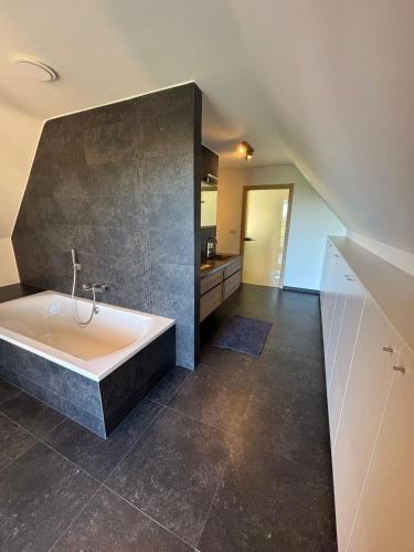 a large bathroom with a tub and a kitchen at 't Caeneghems Goed in Tielt