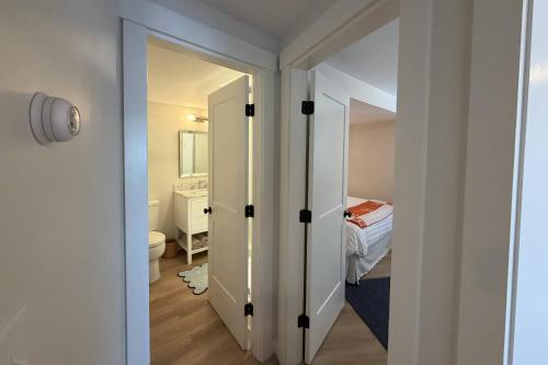 a bathroom with a door leading to a bedroom at Perfectly Scitu8ed - Scituate in Scituate